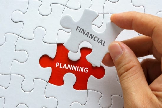 a person is holding a piece of a puzzle with the word financial planning on it .