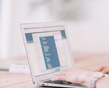 a person is using a laptop computer on a wooden table .