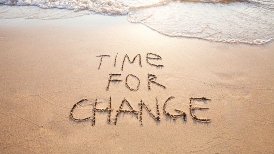 the words `` time for change '' are written in the sand on a beach .