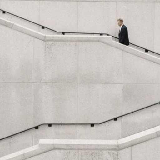 a man in a suit is walking up a set of stairs .