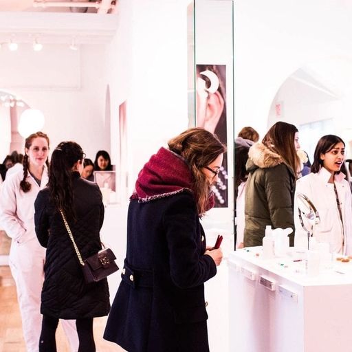 a group of women are standing in a store looking at their phones .