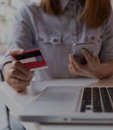 Revolutionizing fashion and beauty image of woman paying with a credit card on phone and laptop