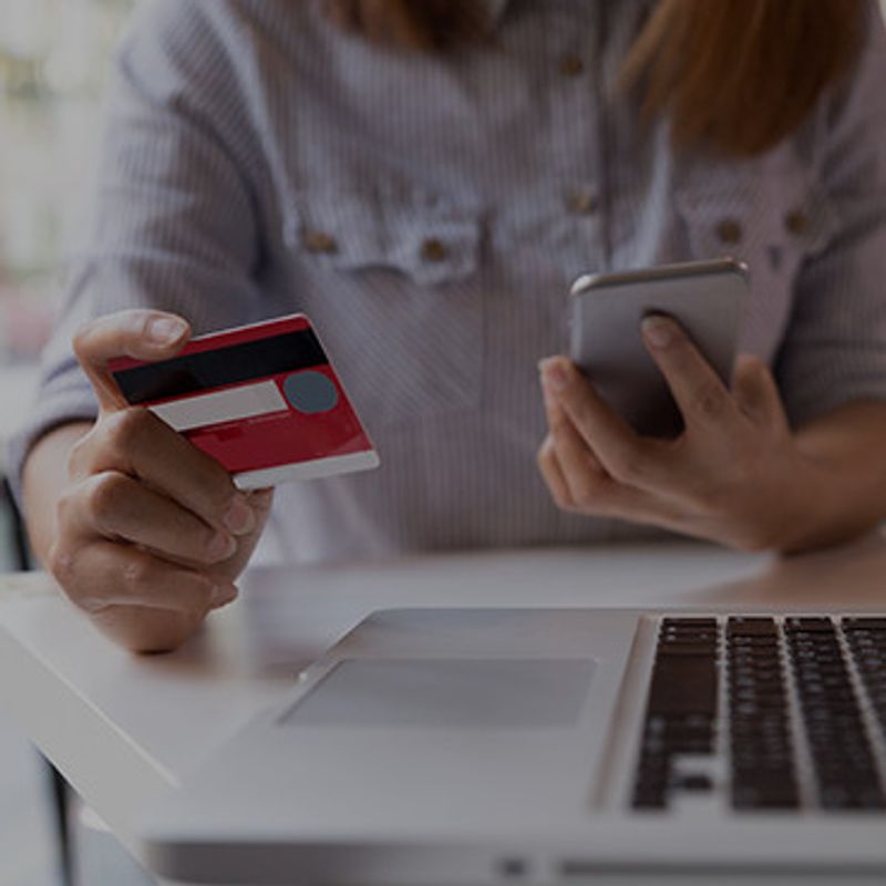Revolutionizing fashion and beauty image of woman paying with a credit card on phone and laptop
