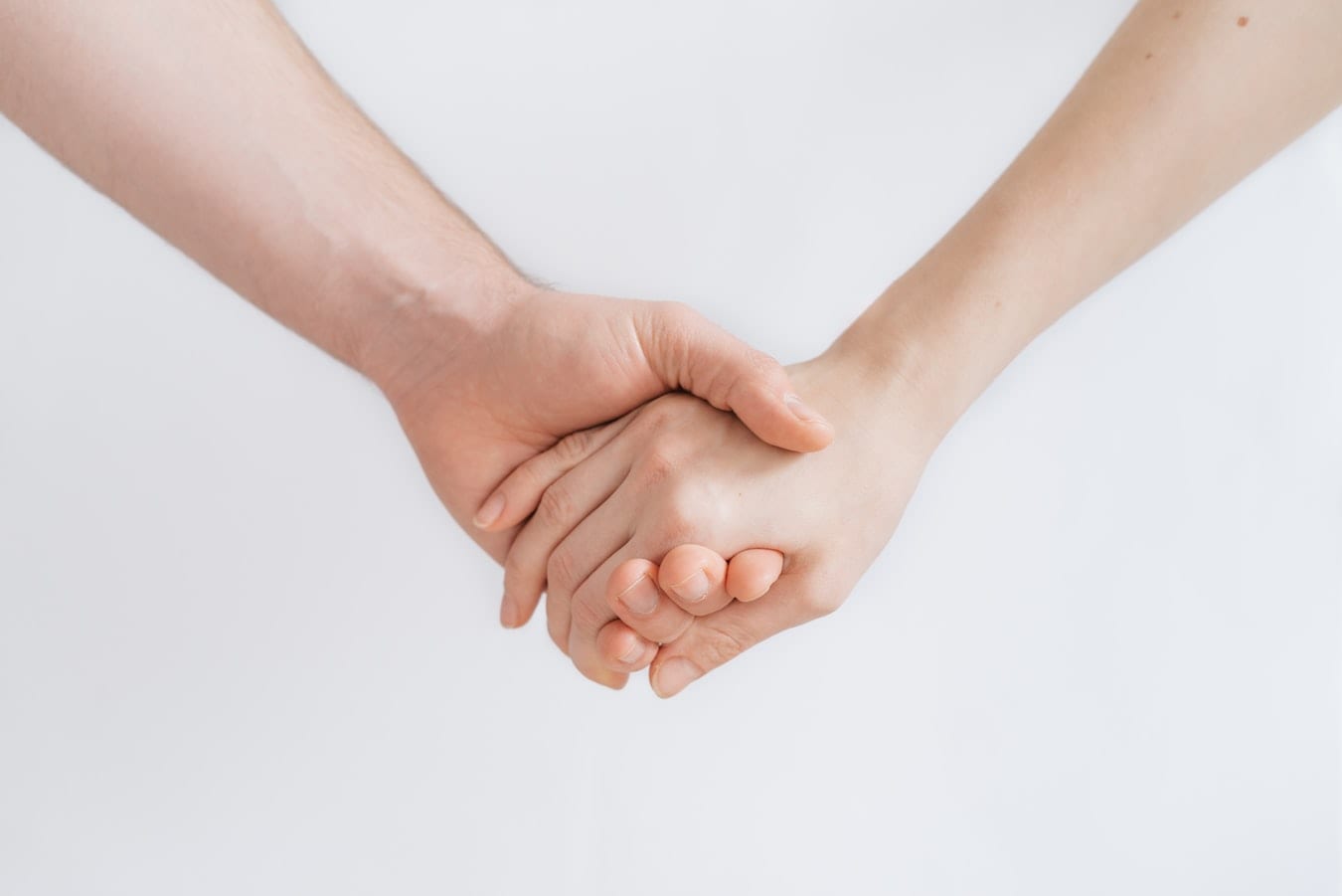 a man and a woman are holding hands on a white background .