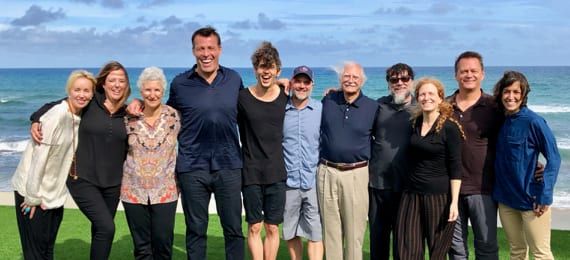 a group of people are posing for a picture on the beach .