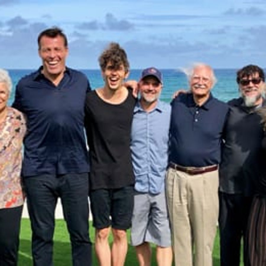 a group of people are posing for a picture on the beach .