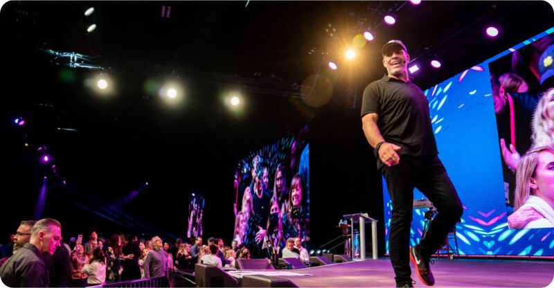 a man is standing on a stage in front of a crowd .
