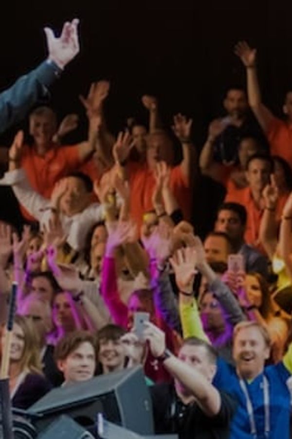 a man is standing on a stage in front of a crowd of people .