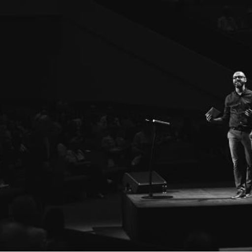 a man is standing on a stage in front of a microphone .