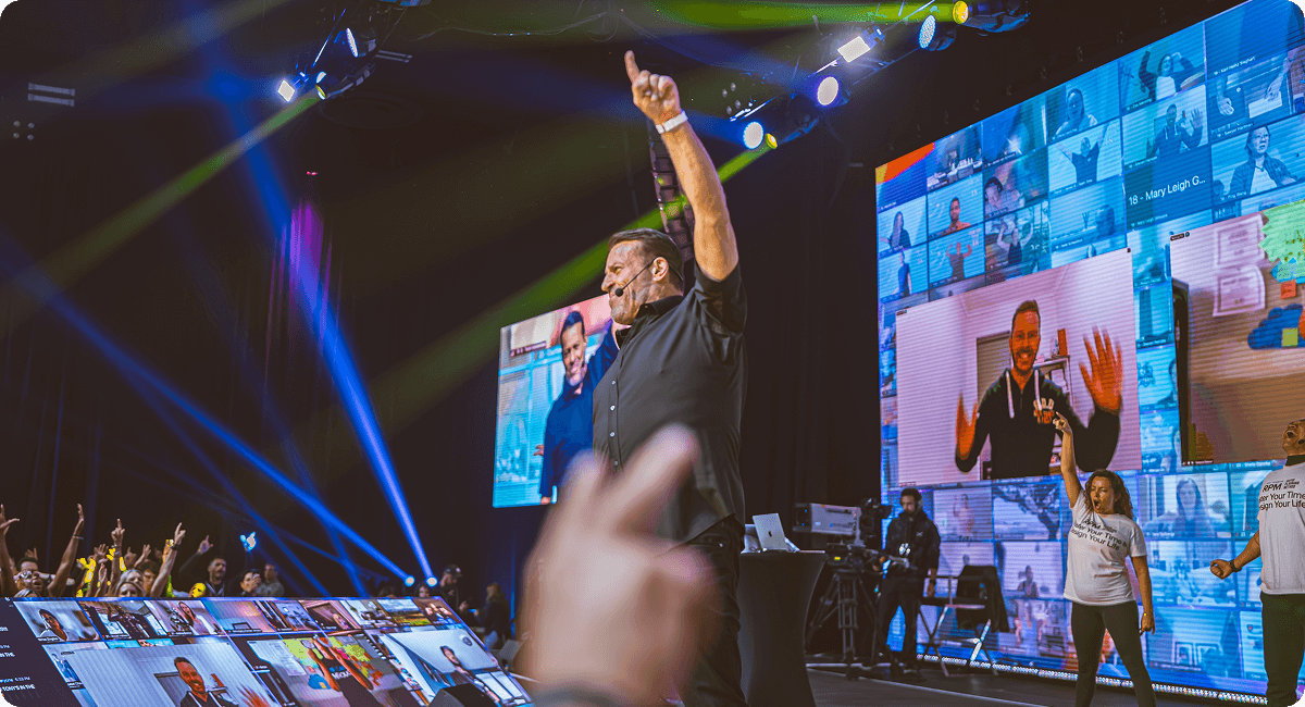 a man stands on a stage with his arms in the air