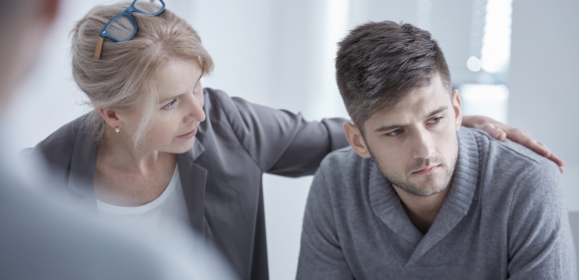 a woman is comforting a man during a therapy session .