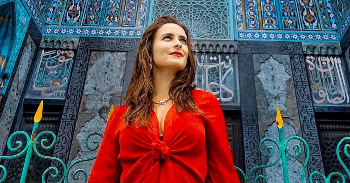 The gift of connection image of woman in red dress in front of blue building