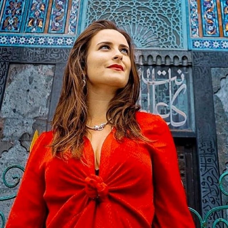 The gift of connection image of woman in red dress in front of blue building