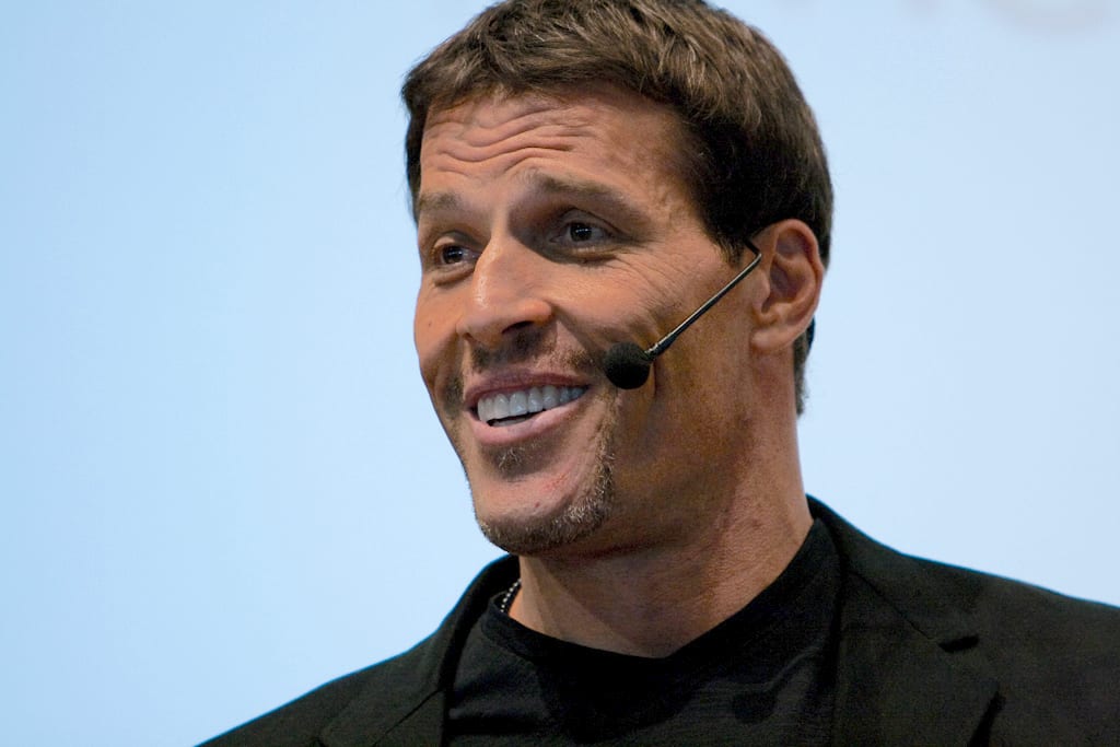 a man is smiling while wearing a microphone in his ear .