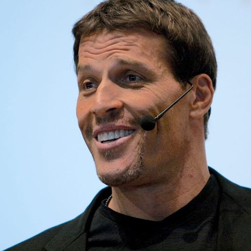 a man is smiling while wearing a microphone in his ear .