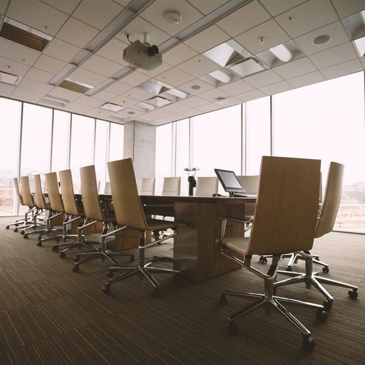 a conference room with a long table and chairs and a lot of windows .