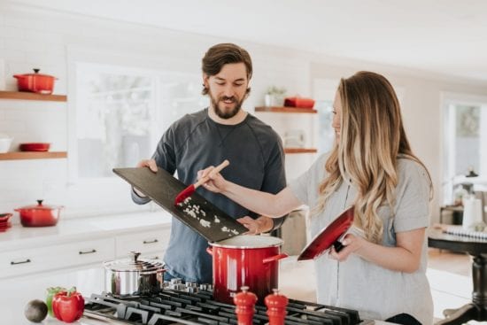 a man and a woman are cooking together in a kitchen .