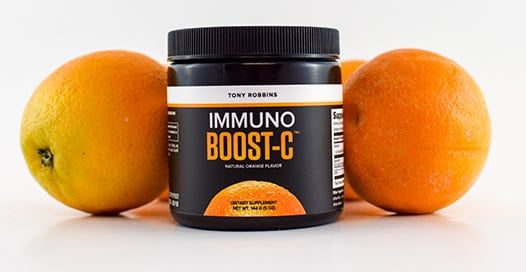 a jar of immuno boost c is sitting on a table next to oranges .