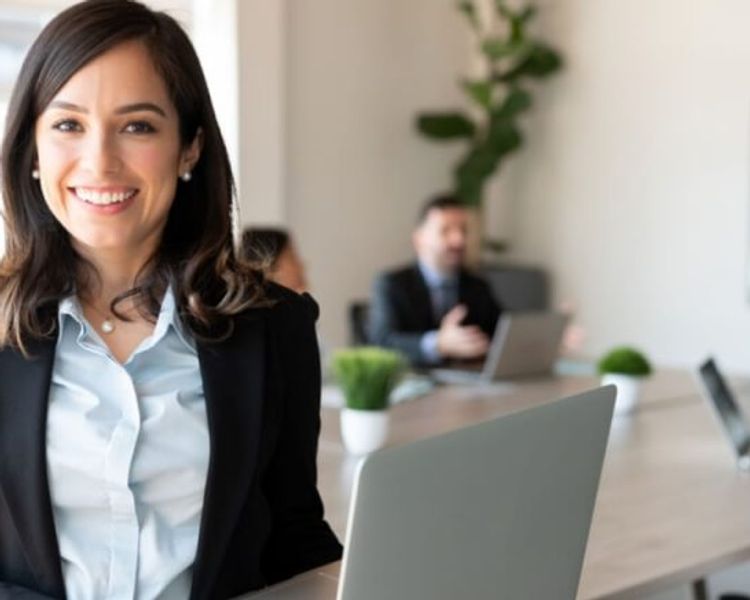 a woman is sitting at a table with a laptop in front of her .