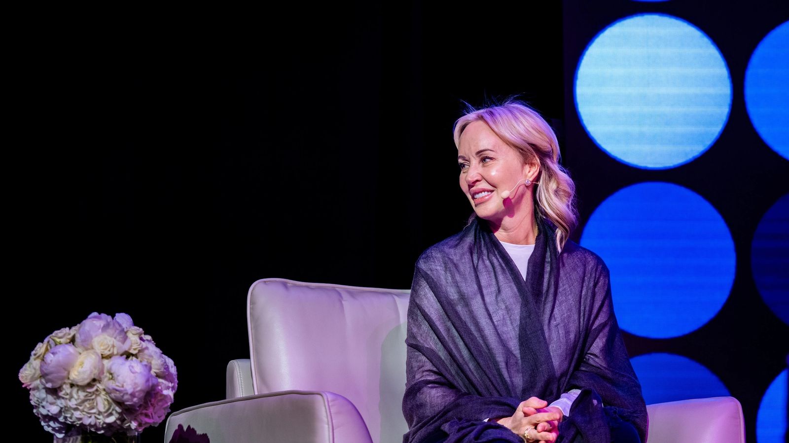 a woman is sitting in a chair on a stage .