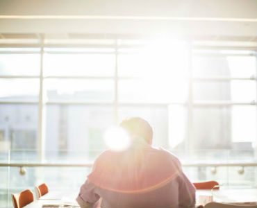 a man is sitting at a table in front of a large window .