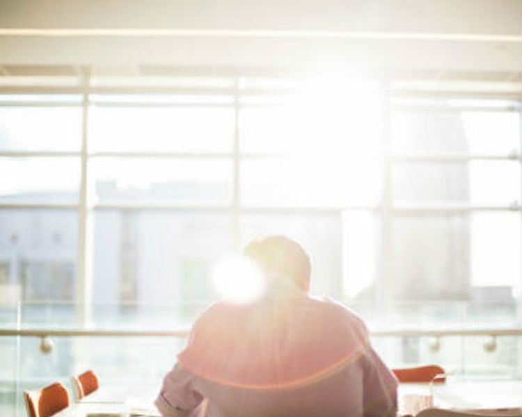 a man is sitting at a table in front of a large window .