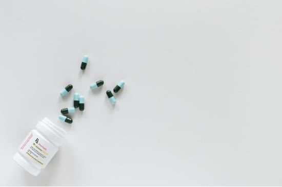 a bottle of pills is spilling out of it on a white surface .