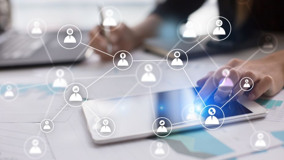 a person is using a tablet with a network of people on it .