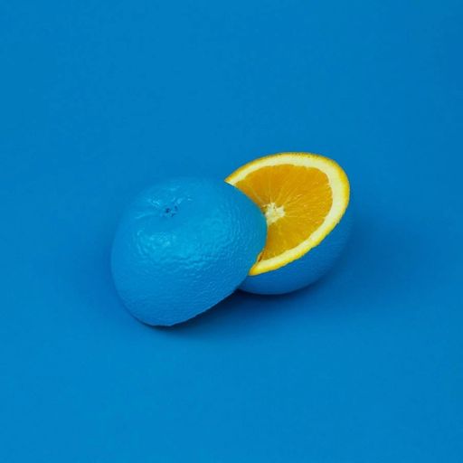 a blue orange with a slice cut out of it on a blue background .