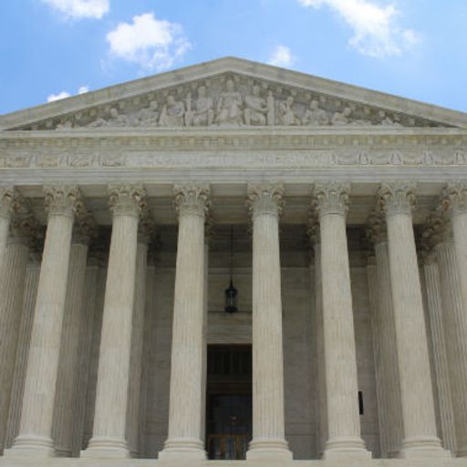 a man is standing on the steps of the supreme court building .