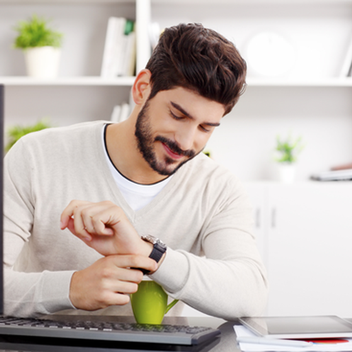 a man sitting at a desk looking at his watch
