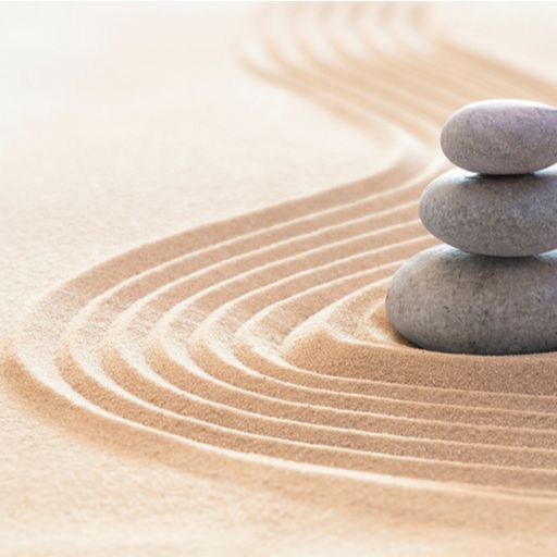 three rocks are stacked on top of each other in the sand .