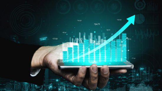 a person is holding a cell phone with a graph on it .