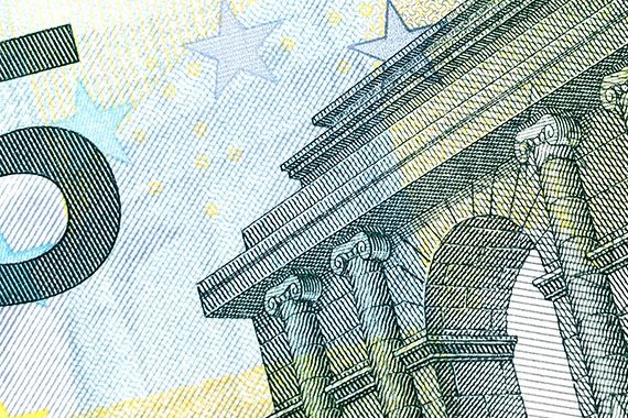 a close up of a 5 euro banknote with a building in the background .