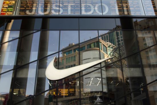 the nike logo is reflected in the windows of a building .