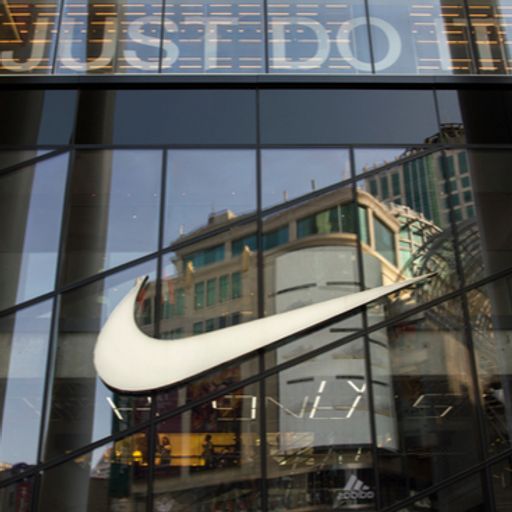 the nike logo is reflected in the windows of a building .