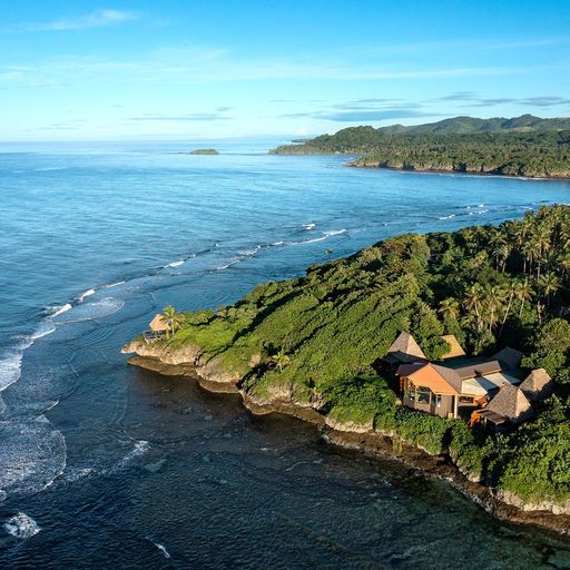 an aerial view of a house on a small island in the middle of the ocean .