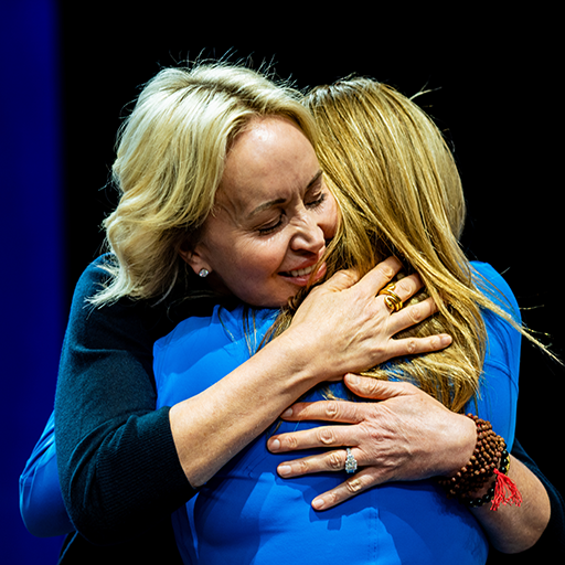 two women hugging each other with one wearing a ring on her finger