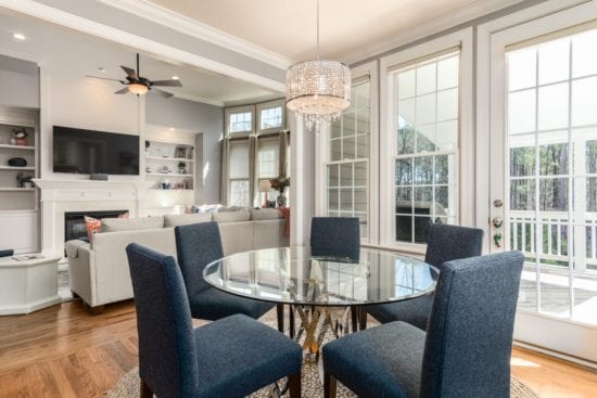 a dining room with a glass table and chairs and a ceiling fan .