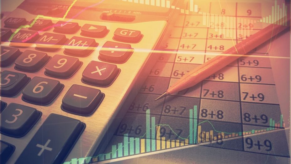 a calculator , pencil , and graph are on a table .