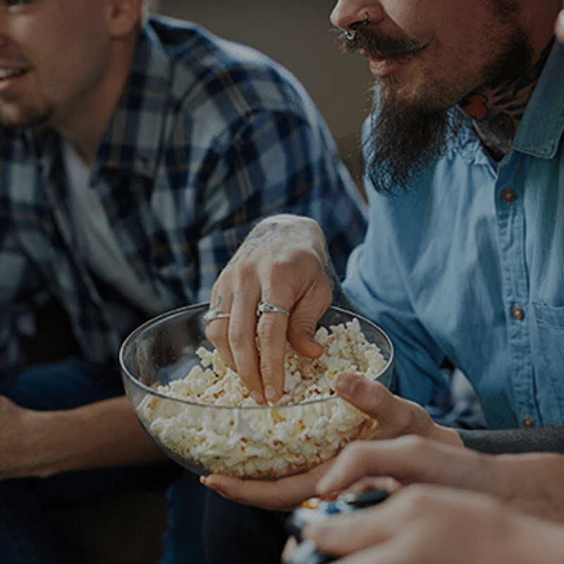 The masculine masks that hurt men image of men eating popcorn together