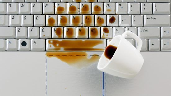 a cup of coffee spilled on a computer keyboard