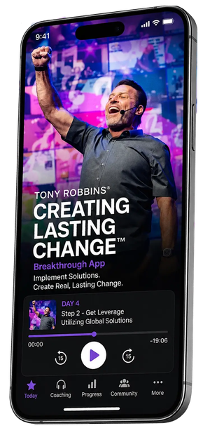 A smartphone displays the Tony Robbins "Creating Lasting Change Breakthrough App," featuring Tony Robbins raising a fist on a video screen.