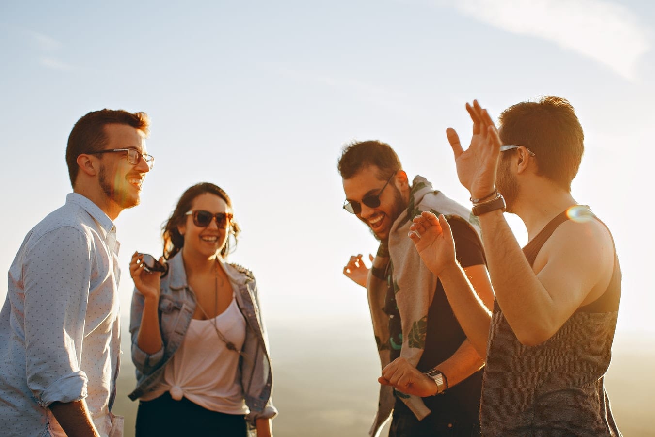 a group of young people are standing next to each other on top of a hill .