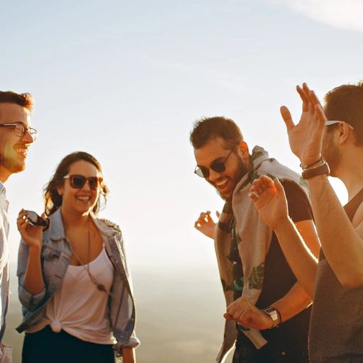 a group of young people are standing next to each other on top of a hill .