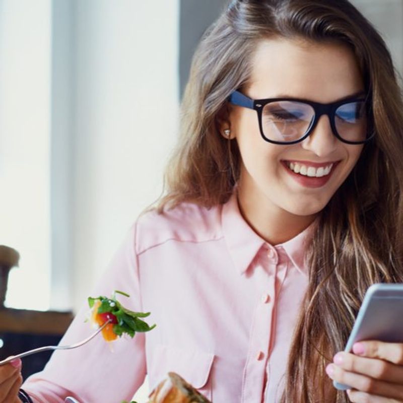 Achieving unstoppable energy image of woman eating healthy foods looking at phone
