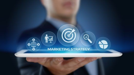 a man is holding a tablet with a marketing strategy displayed on it .