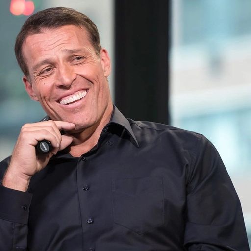 a man in a black shirt is smiling while holding a microphone .