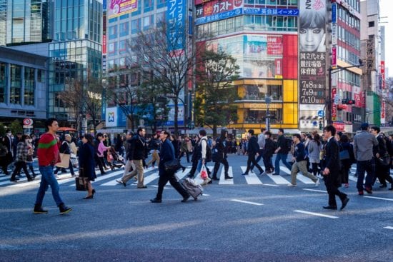a crowd of people are crossing a street in a city .
