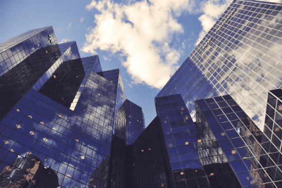looking up at a row of skyscrapers with a blue sky in the background